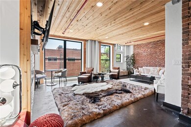 Living room with wood ceiling, finished concrete floors, brick wall, and recessed lighting