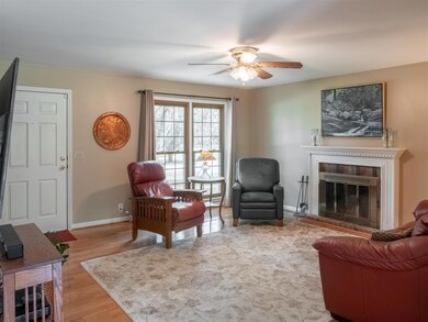 A light-filled living room with a cozy wood-burning fireplace.