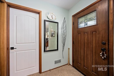 Entryway with light colored carpet and baseboards