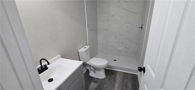 Full bath with vanity, toilet, a stall shower, and
