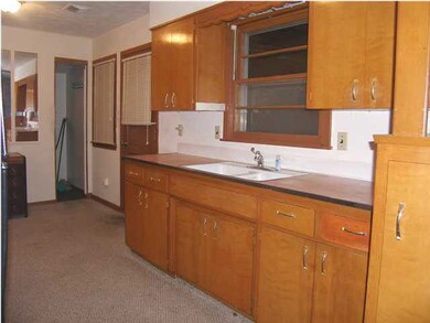 The west wall of the kitchen. There is a small are