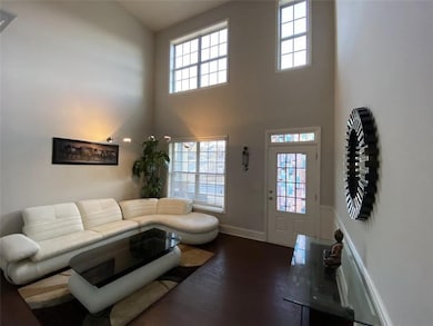 Living room with a high ceiling and dark wood-type flooring
