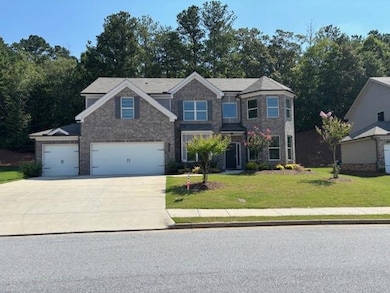 Craftsman-style house featuring a front lawn, concrete driveway, brick siding, and a garage