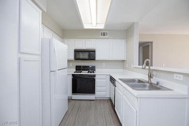 Kitchen with gas range, black microwave, freestand
