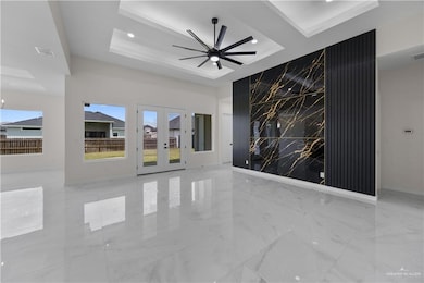 Empty room with a raised ceiling, french doors, recessed lighting, ceiling fan, and marble tiled floors