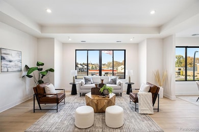 Living room with light wood-style floors, plenty of natural light, and recessed lighting