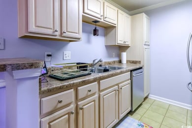 Kitchen featuring stainless steel dishwasher, a sink, crown molding, light tile patterned floors, and baseboards