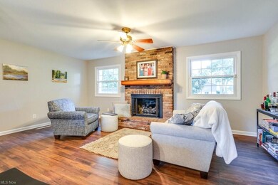 Living room with brick wall, ceiling fan, a firepl