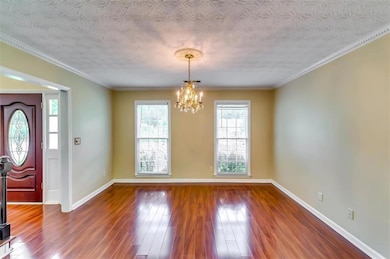 Foyer entrance with a chandelier, hardwood / wood-style flooring, and a textured ceiling