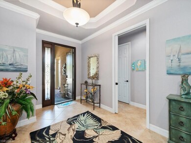Foyer with baseboards, ornamental molding, and lig