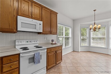 Kitchen with white appliances, brown cabinets, a c