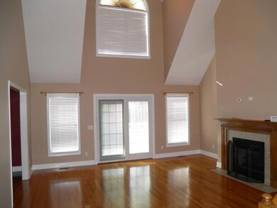 Large living room with a vaulted ceiling, hardwood floors, gas fireplace, and lots of windows to allow natural light.  Electrical sockets have been added to the floor.  Top of the line Pella sliding patio doors. 