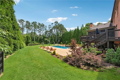 Outdoor pool with a deck, stairs, a yard, and a patio area