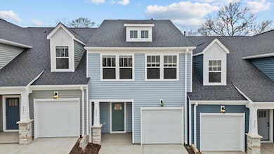 Townhome with blue siding, craftsman style exterior, large widows, garage and two car parking pad in Lyman, SC at Aspen Ridge