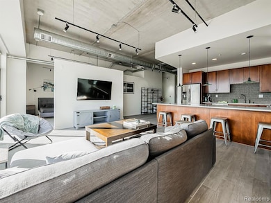 Living room featuring rail lighting and light wood-style floors