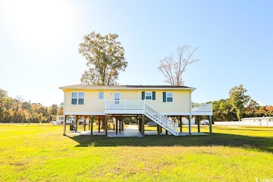 Rear view of house featuring a yard, stairway, a wooden deck, and a patio