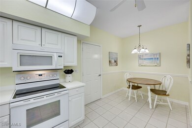 Kitchen with white appliances, white cabinets, dec