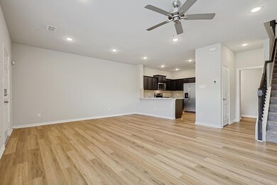 Unfurnished living room with ceiling fan and light wood-type flooring