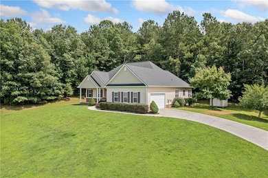 View of front of property with concrete driveway, a front yard, and an attached garage