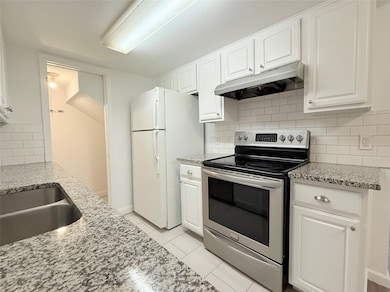 Kitchen featuring under cabinet range hood, stain