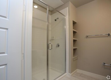 Bathroom with a shower with door and wood-type flo