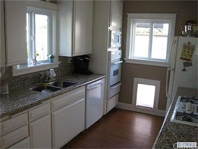 Kitchen with granite counters and door to the encl