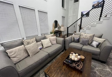 Living area featuring stairway and carpet