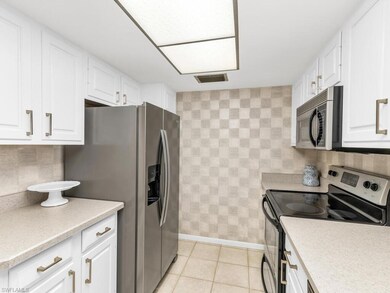 Kitchen featuring white cabinetry, decorative back