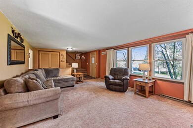 Living room featuring a textured ceiling and carpe