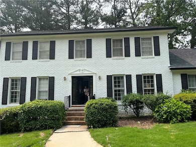 Colonial-style house with brick siding and a front yard
