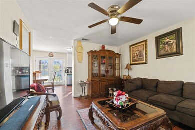 Living room featuring ceiling fan, dark wood-type 