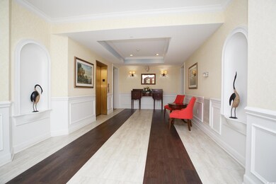Corridor featuring a raised ceiling, crown molding