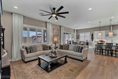 Living room with visible vents, a ceiling fan, lig