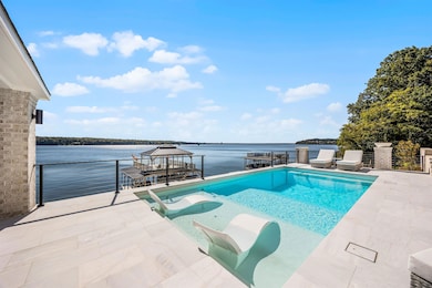 View of pool with a gazebo, a patio, and a water view