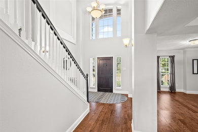 Entryway with a chandelier, dark wood-type flooring, stairway, and a high ceiling
