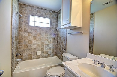 This bathroom features a shower-tub combo with bei