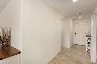 Hall with recessed lighting and light tile pattern