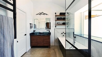Full bathroom with concrete flooring, lofted ceil