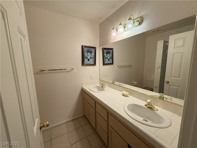 Bathroom with double vanity, tile patterned floori