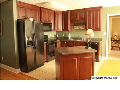 Kitchen with island. The island has pull out drawers that can be used for pots & pans, Plenty of cabinet & counter top space in this conveniently set up kitchen. Black Whirlpool appliances includes fridge.
