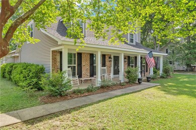 View of front of house featuring a porch, a front yard, a shingled roof, and brick siding