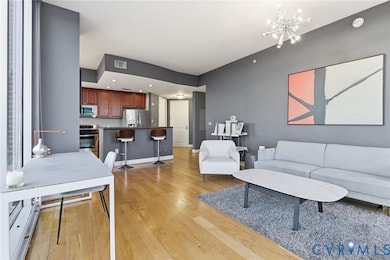 Living area featuring light wood-style floors, a chandelier, and recessed lighting