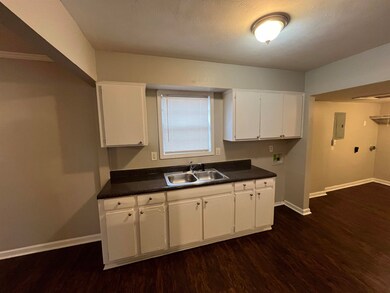 Kitchen with dark countertops, dark wood-style flo