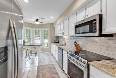 Kitchen featuring ceiling fan, tasteful backsplash
