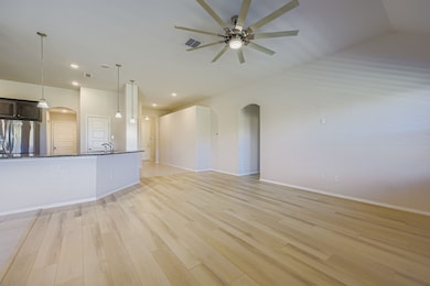 Unfurnished living room featuring arched walkways, light wood finished floors, and recessed lighting