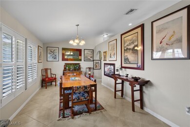 Tiled dining area with lofted ceiling and a chandelier
