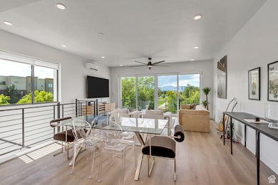 Dining area with light wood-style floors, healthy amount of natural light, recessed lighting, a ceiling fan, and a wall unit AC
