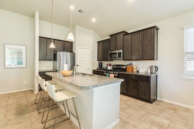Granite countertops, dark wood cabinets and stainless appliances complete this well laid out kitchen space.