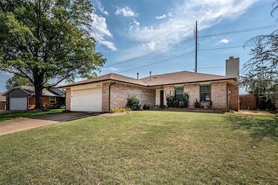 Ranch-style house with a garage and a front lawn
