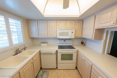 Kitchen with white appliances, light countertops,